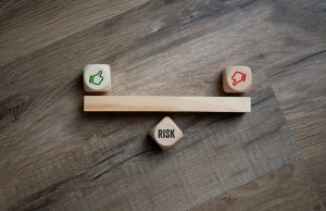 Cubes dice with thumbs up and down and risk on wooden background 